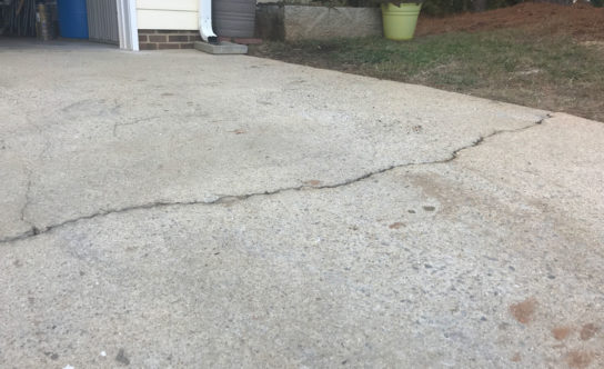 Cracks in concrete driveway of Holly Springs NC home before concrete lifting solution